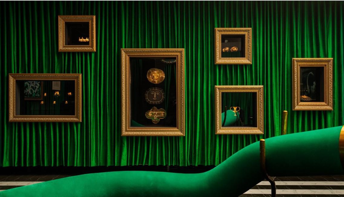 Artworks hang in a velvet clad room.