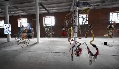 A group of hanging sculptures in a raw space.