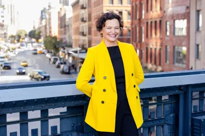 Portrait of Cecilia Alemani, standing on a section of the High Line that crosses over a Manhattan street below.