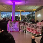 A group of protestors in a museum lobby.
