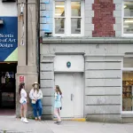 An exterior image of the Nova Scotia College of Art and Design in Halifax, Nova Scotia, with three young women standing outside