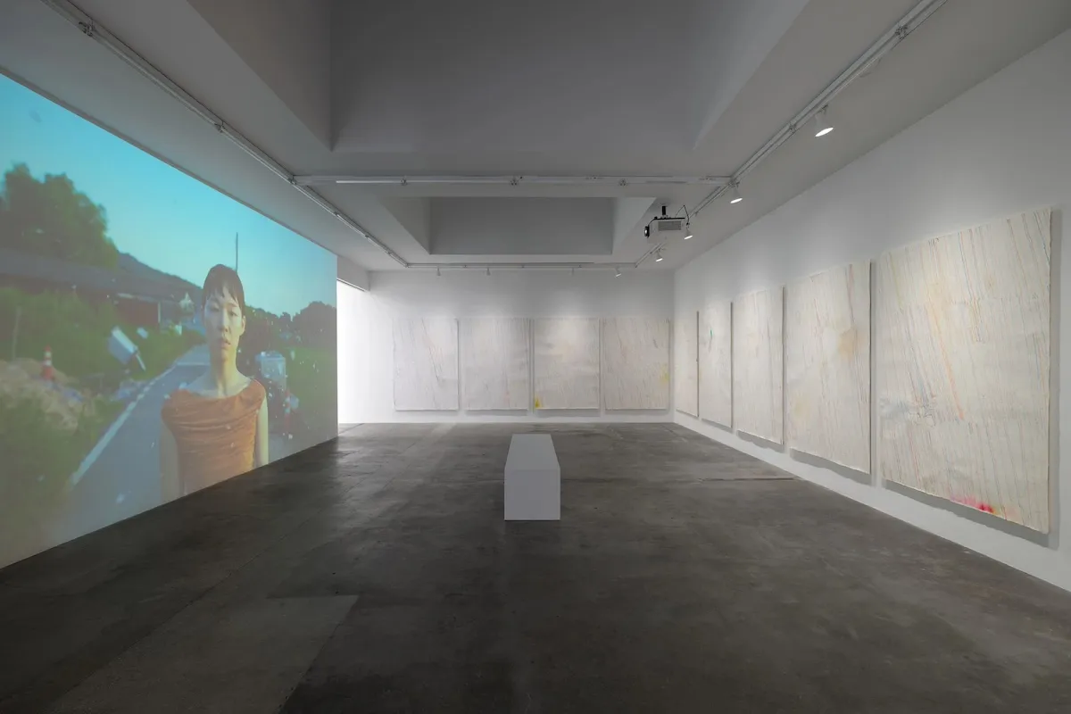 An empty gallery with a video projection on one wall.