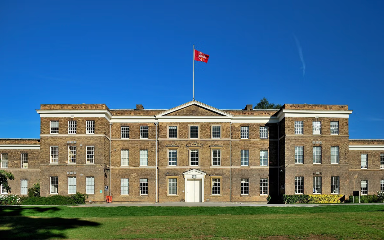 A building under a blue sky with a lawn in front.