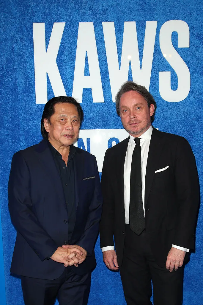 Two men in suits beneath a sign that says