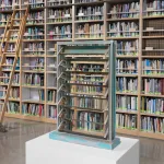 A sculpture of a window in front of a tall bookshelf with a stepladder.