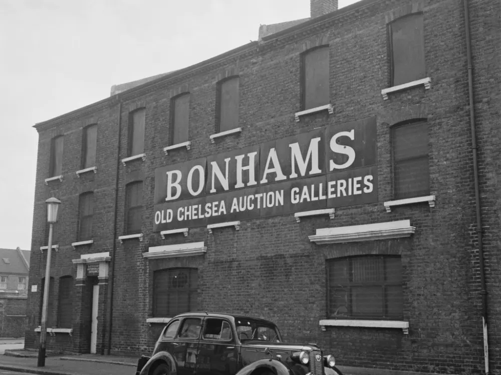 A three-story brick building is seen from an angle. Its facade reads, 