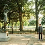 A man, curator Paul Farber, poses with a version of the 8-foot-tall statue of Rocky Balboa in Philadelphia.