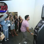 MIAMI BEACH, FL - DEC 3: Sajan Patel receives  dollars from an ATM Leaderboard installation presented by Perrotin during Art Basel Miami Beach in the Miami Beach Convention Center on Saturday, December 3, 2022 in Miami Beach, Florida. (Photo by Sean Drakes/Getty Images)