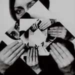A black and white photo of a woman holding photos.