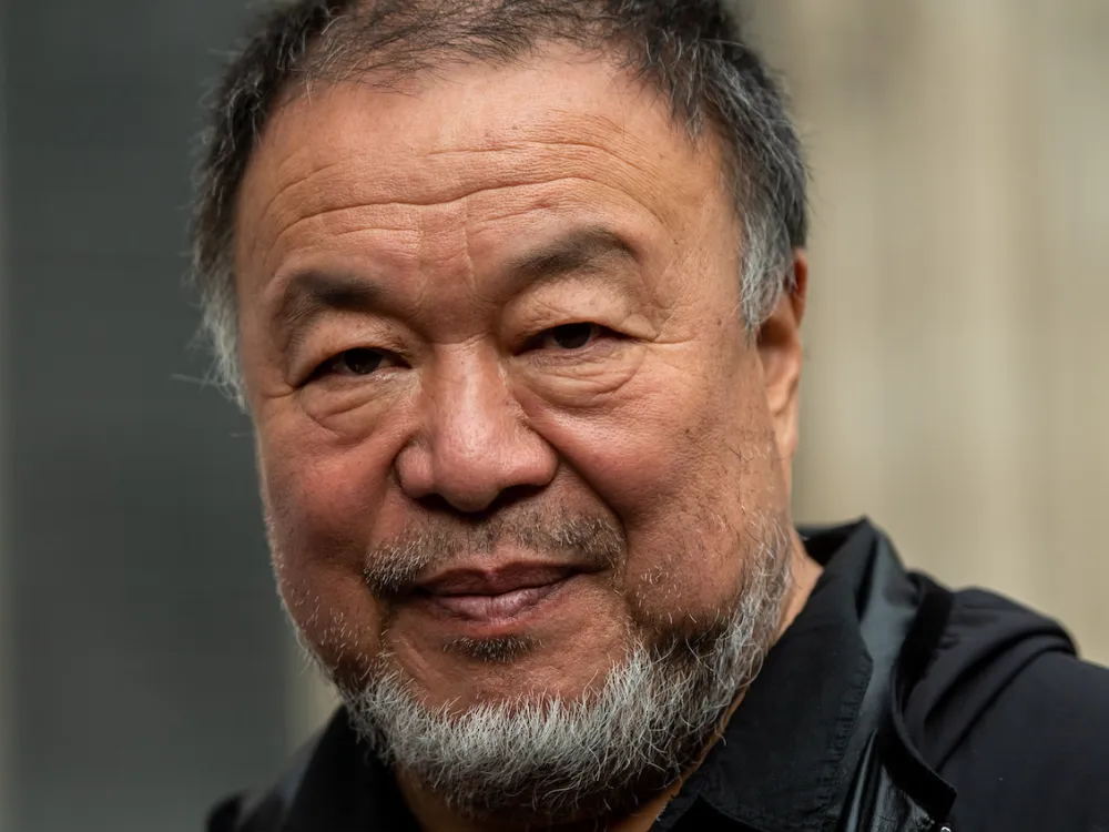 A close-up shot of the artist Ai Weiwei smiling.