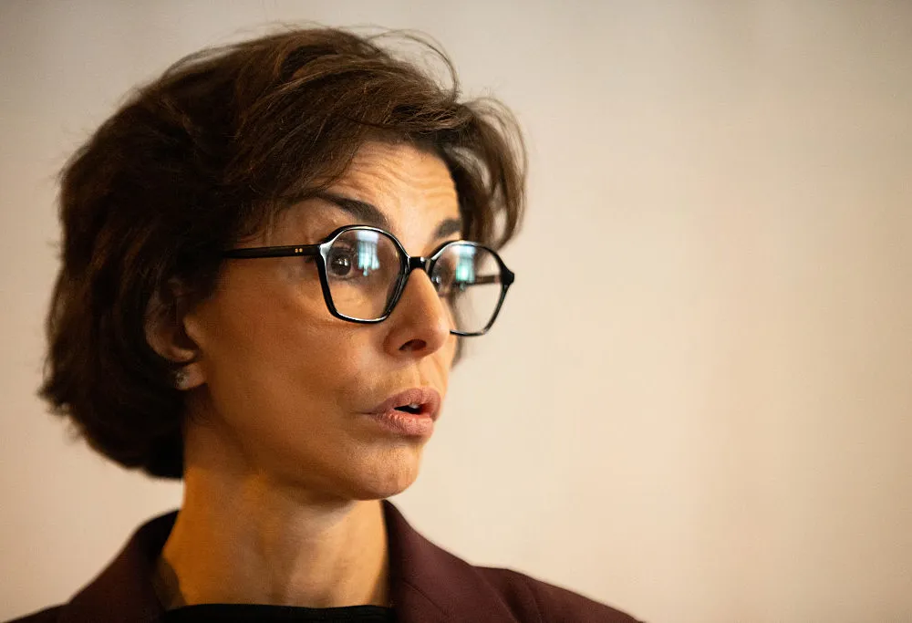 A woman wearing glasses with brown hair.