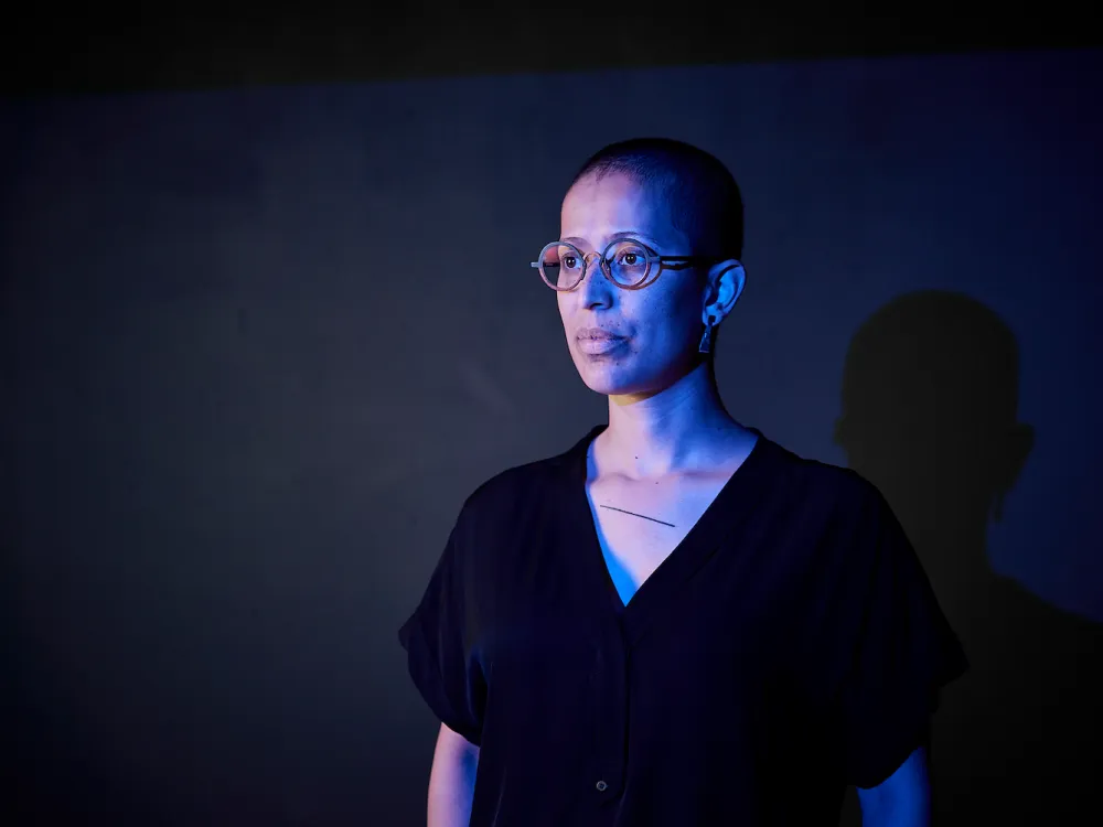 A portrait of a Black woman in a gradient of blue light.