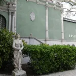 A sculpture of a half-naked woman outside a pavilion with the word 