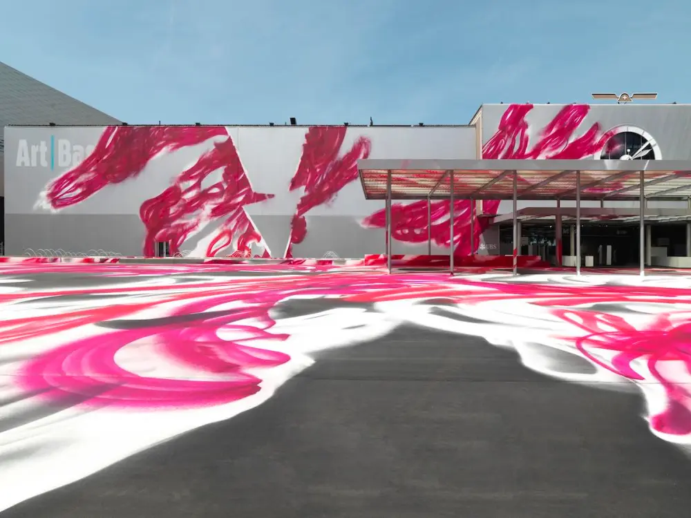 A convention center partially covered in pink swirls of paint.
