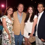 Four well-dressed white people pose, smiling for the camera. They are Lisa Fayne Cohen, Jimmy Cohen, and two of their children.