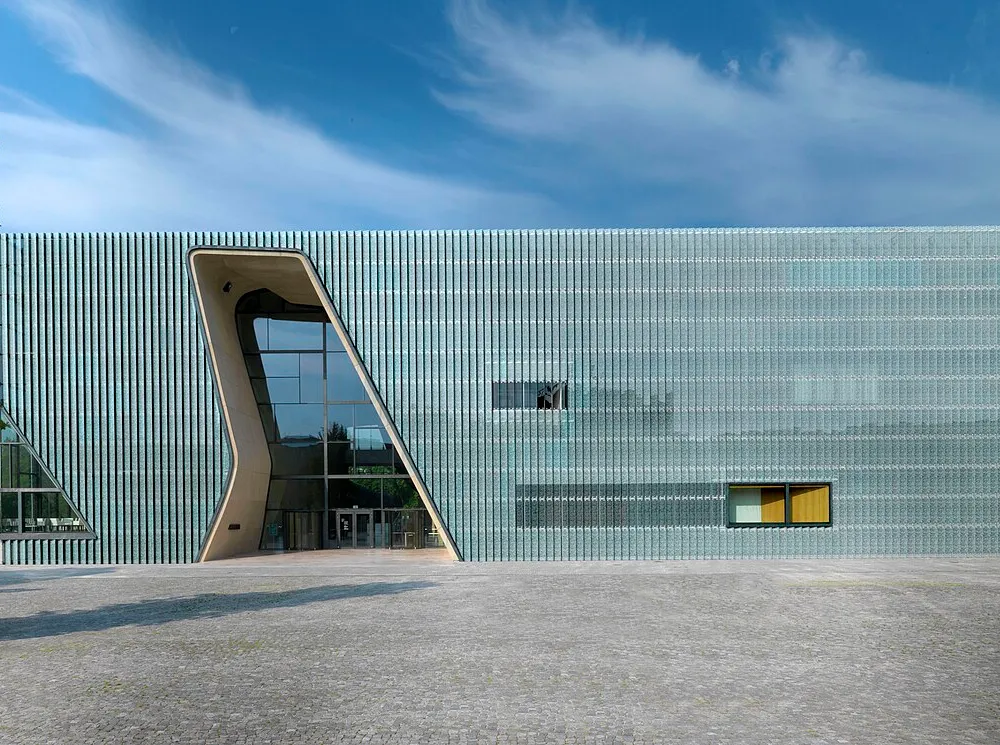 A rectangular building with a glass face and irregular entrance.