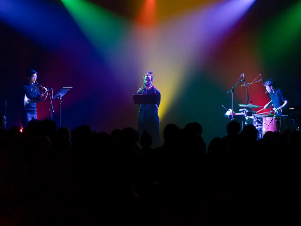 People standing on a stage beneath mulitcolor lighting.