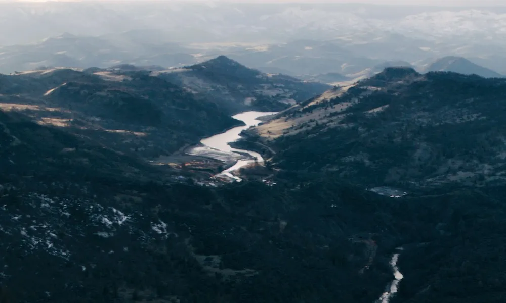 An aerial view of a river coursing through mountains.