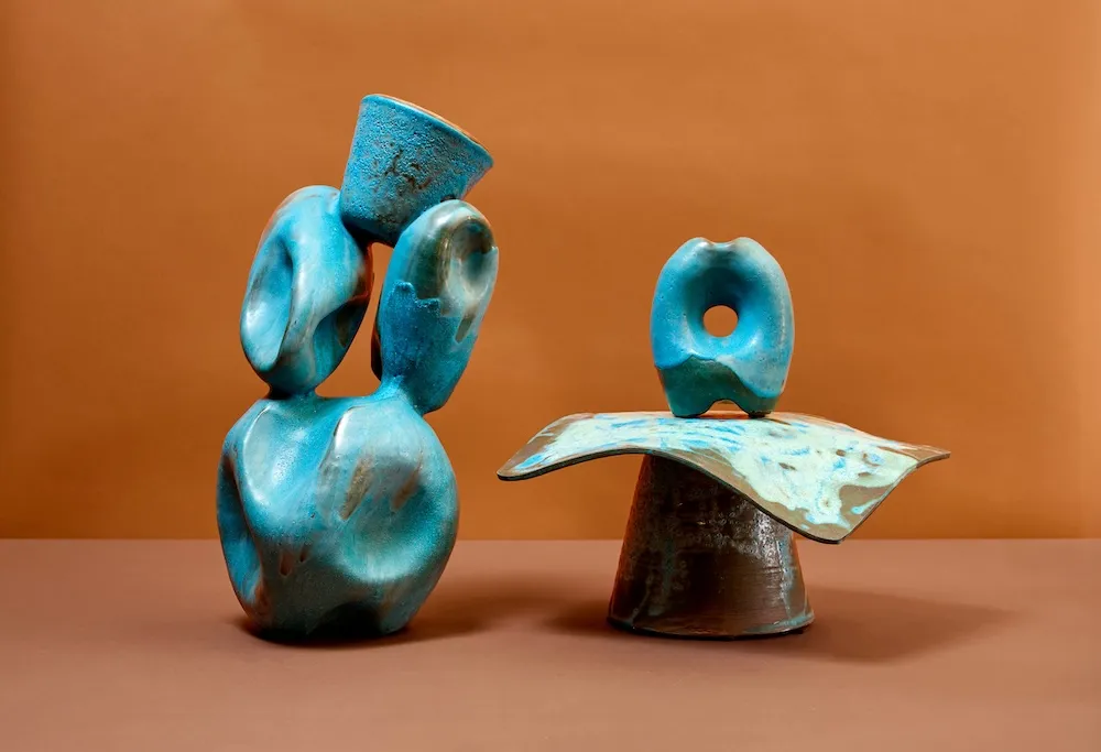 Two bronze sculptures comprised of thick circles on what appear to be unsteady organize looking bases.