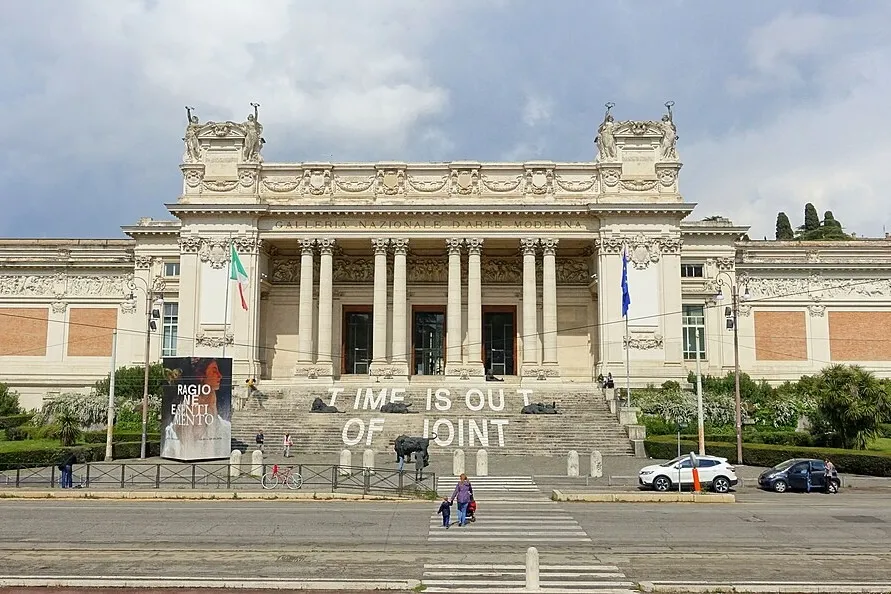 A grand pale stone building lined with columns.