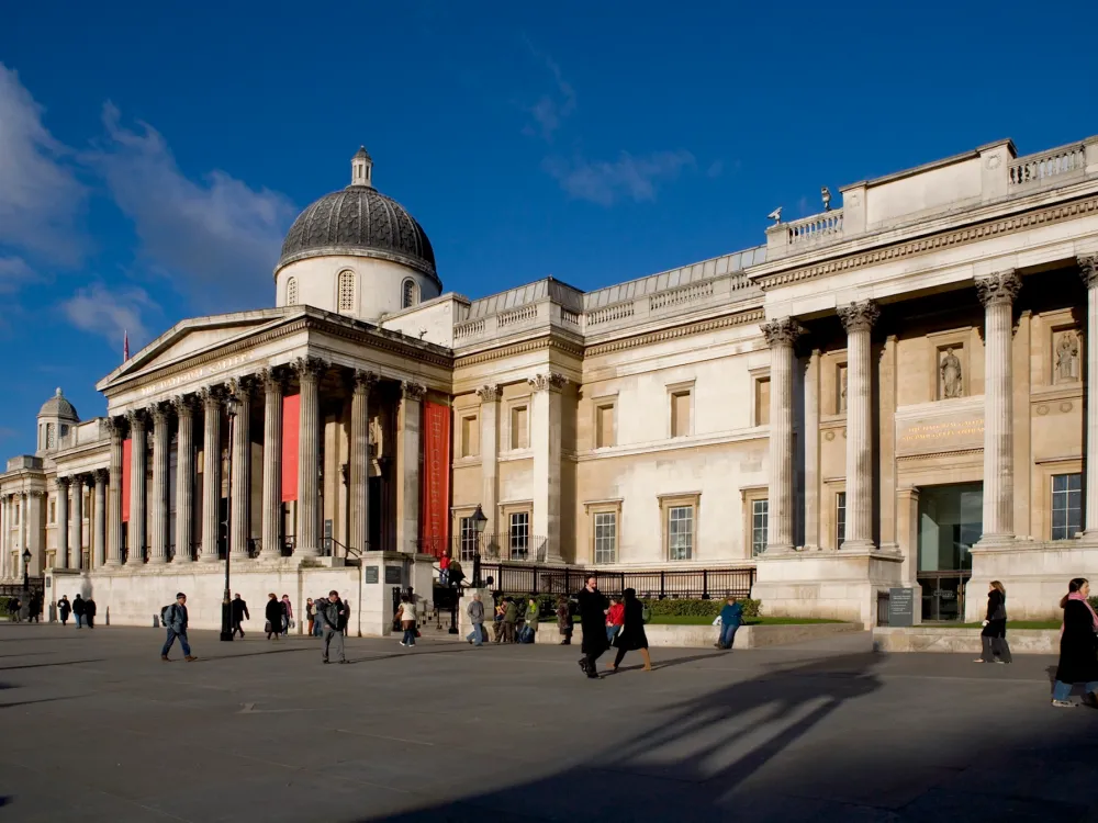 A photograph shows a large building in the Greek classical style, with a large portico with columns.