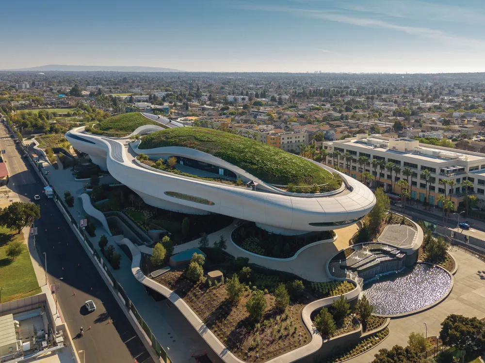 A museum with arcing edges and greenery on its roof and around its structure seen from above.
