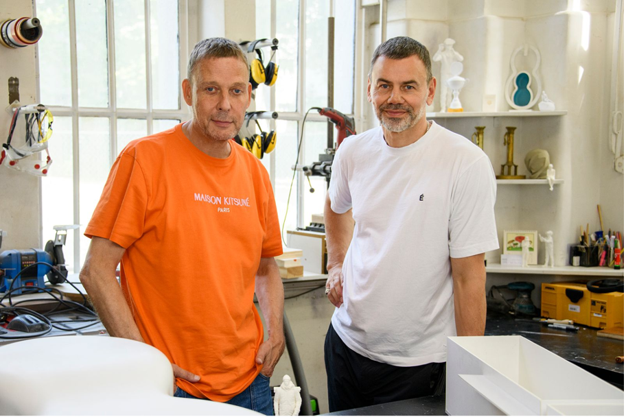 Two men standing in their sculpture studio.