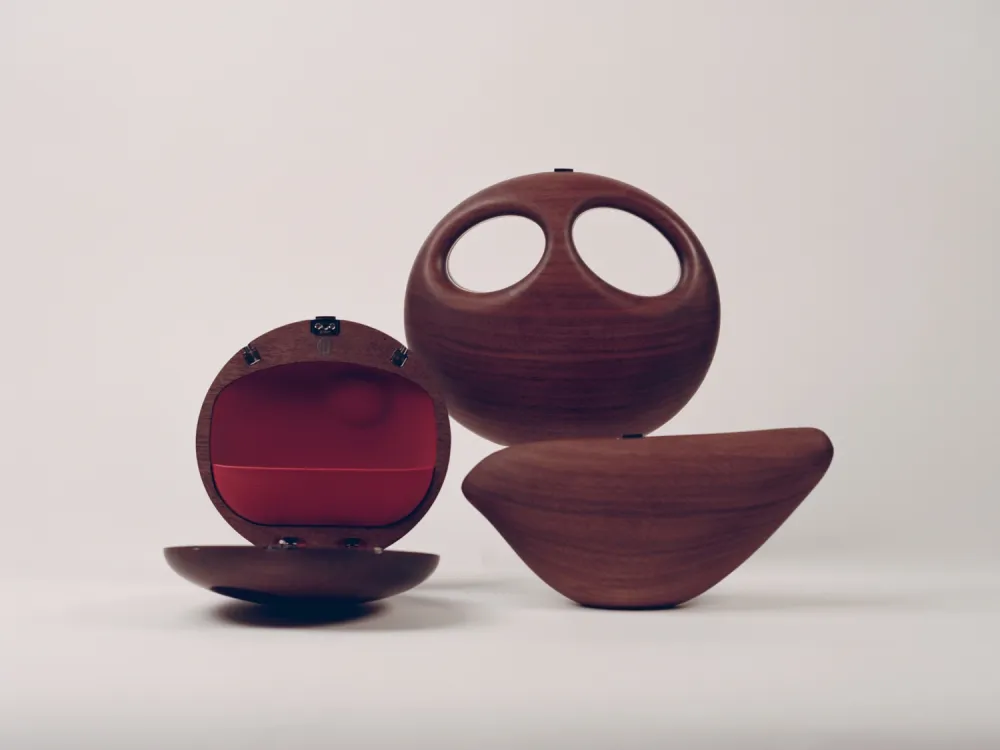 Three wooden handbags, one with a red interior.