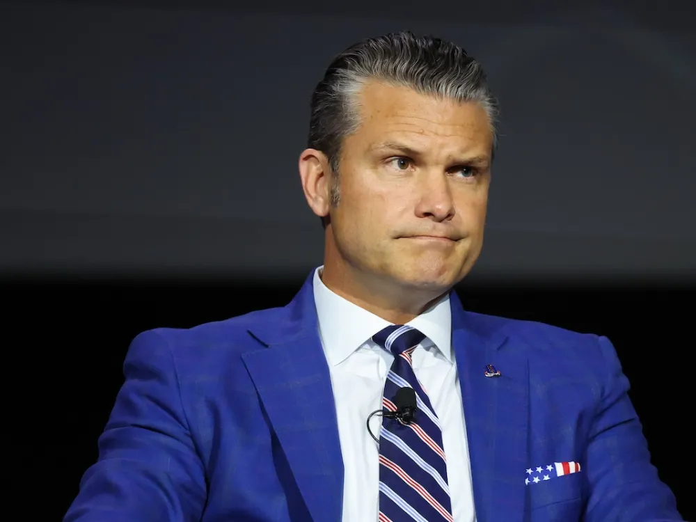 A man in a suit smirking.