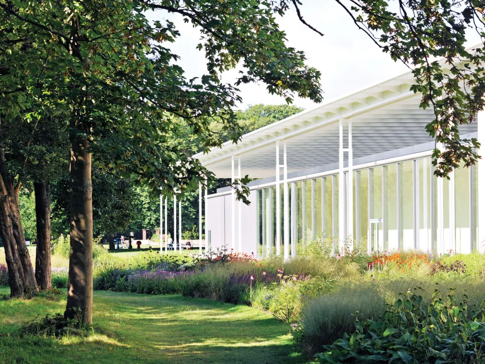 A building surrounded by a lush garden (in the foreground).